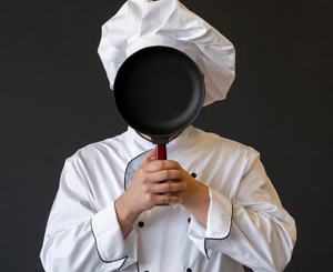 Chef with pan in front of face | Freepik